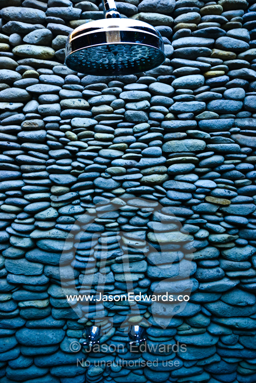 An elegant and unusual shower wall built of volcanic river stones. The Temple Lodge, Bukit Peninsula, Bali, Indonesia.