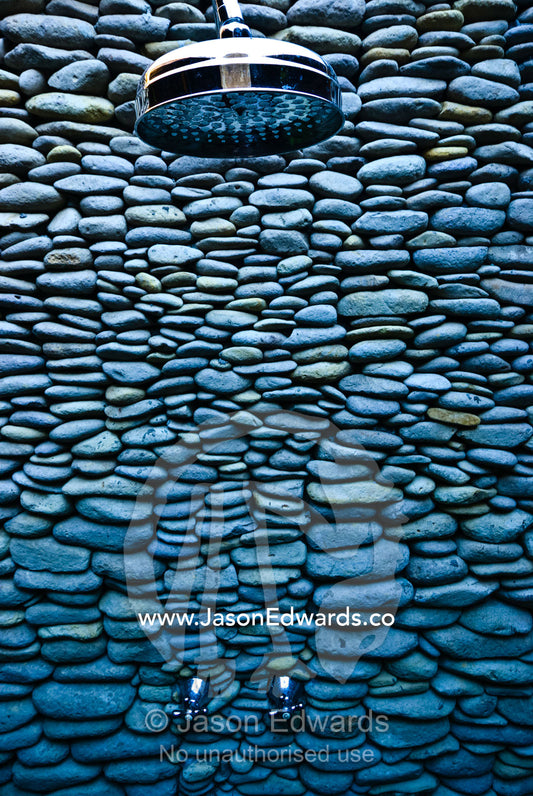 An elegant and unusual shower wall built of volcanic river stones. The Temple Lodge, Bukit Peninsula, Bali, Indonesia.