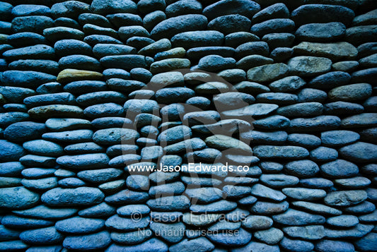 An elegant and unusual bathroom wall built of volcanic river stones. The Temple Lodge, Bukit Peninsula, Bali, Indonesia.