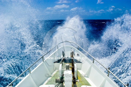 The bow of a ship ploughs through heavy seas and spray in open ocean. Coral Sea Islands Territory, Australia.