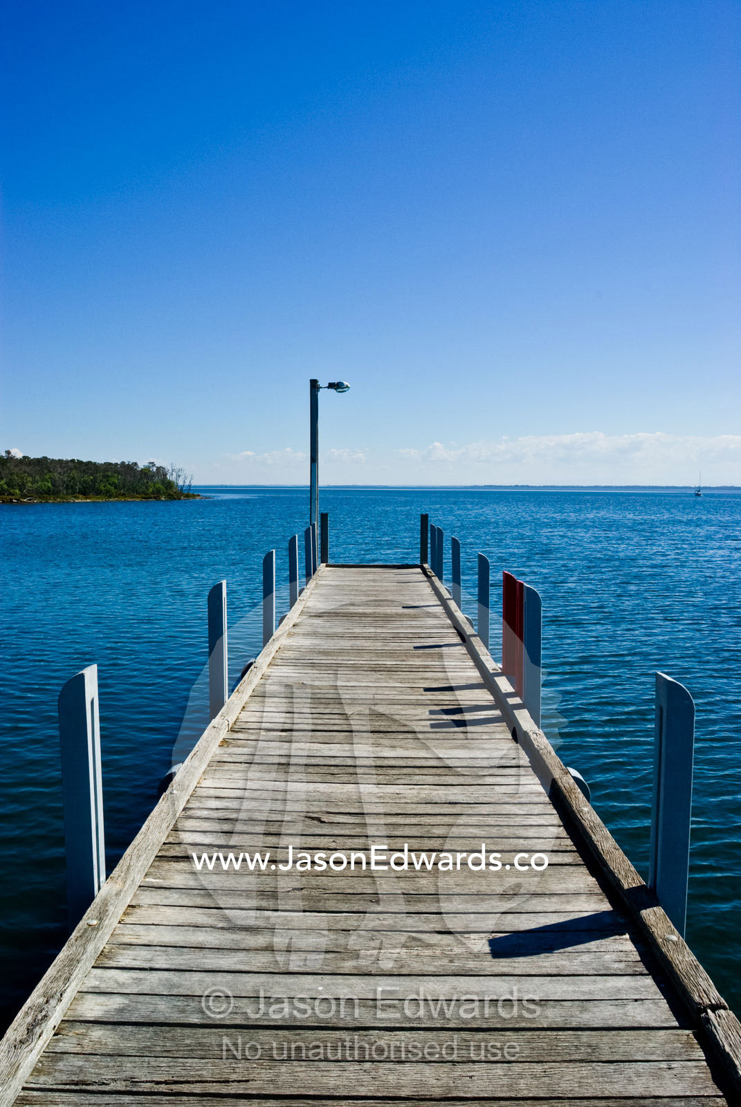 A small jetty in a sheltered and secluded bay on a summers morning. Loch Sport, Lake Victoria, Gippsland, Victoria, Australia.