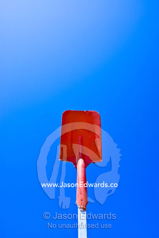 In a public art display a bright red spade rises into the desert sky. near Euriowie, outback western New South Wales, Australia.