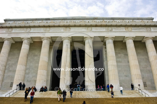 Tourists pass Grecian columns surrounding a statue of Abraham Lincoln. Lincoln Memorial, Washington Mall, National Mall, Washington, DC, United States of America.