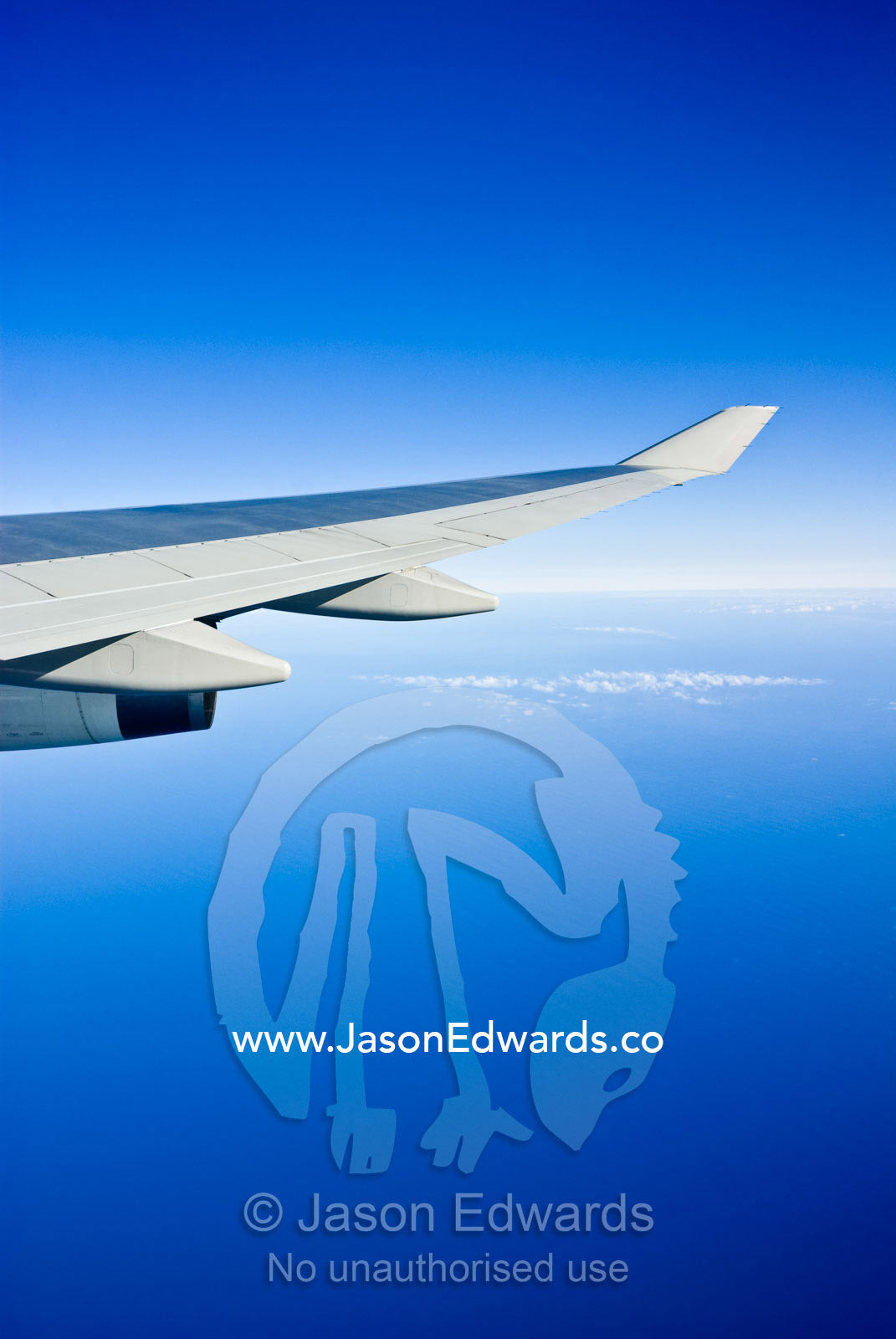 A jet airliner wings it's way across the Pacific Ocean on a clear day. Pacific Ocean between the United States of America and Australia.