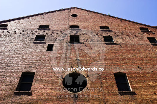 Dark shadowed windows in the facade of a restored colonial factory. Melbourne, Victoria, Australia.
