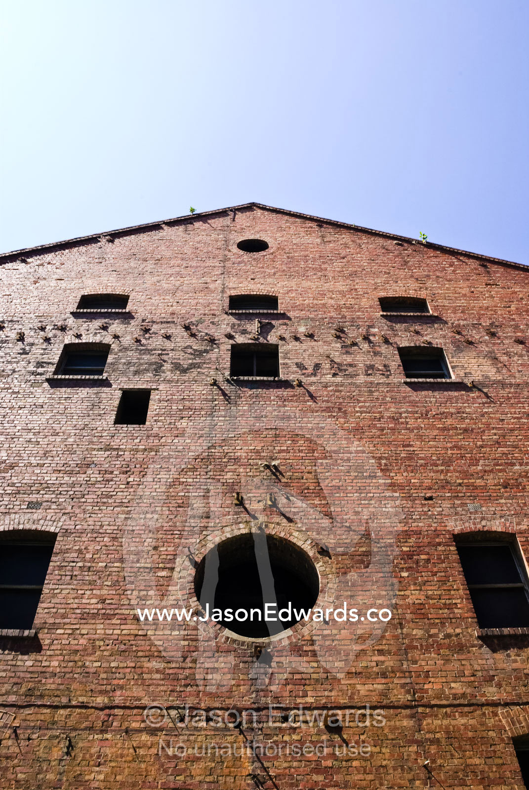 Dark shadowed windows in the facade of a restored colonial factory. Melbourne, Victoria, Australia.
