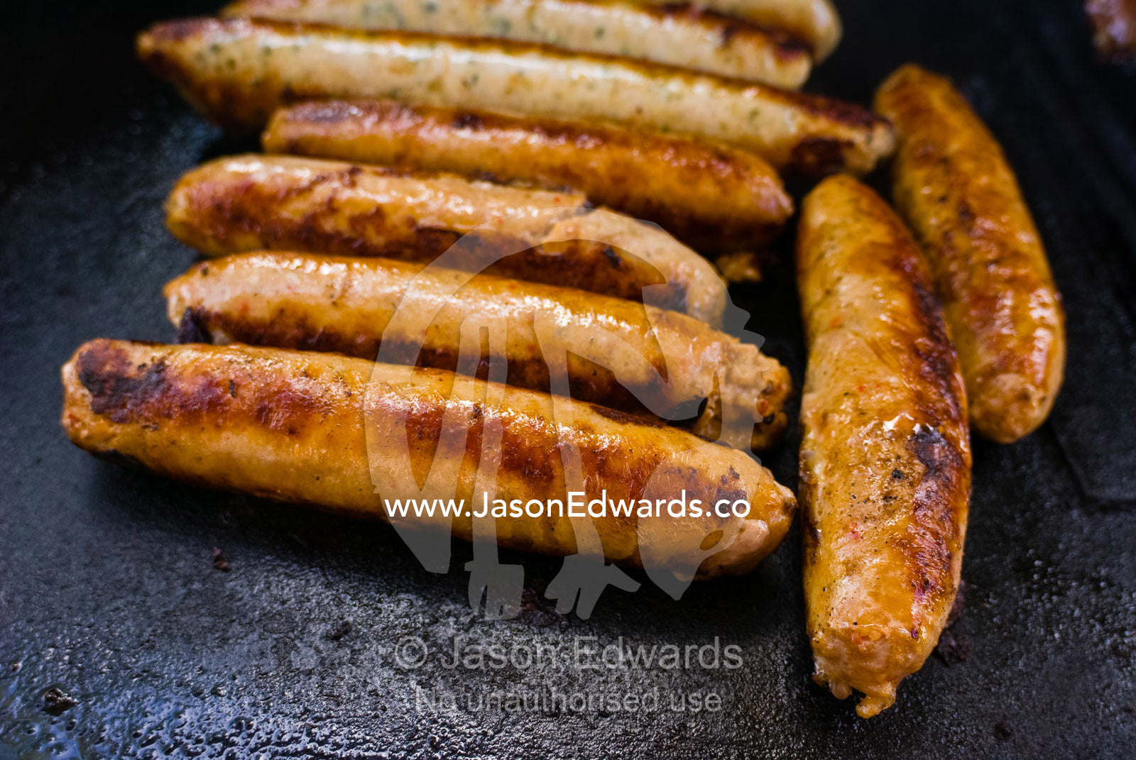 Beef sausages turn golden-brown whilst sizzling on a barbeque grill. Mount Martha, Victoria, Australia.