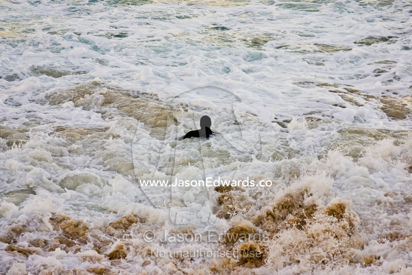 A lone swimmer battles turbulent currents and a treacherous sea. Gunnamatta Beach, Point Nepean National Park, Victoria, Australia.