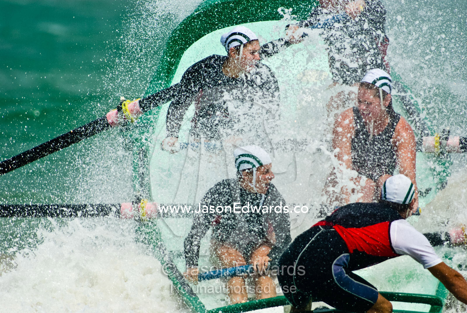 Women row a surf boat through raging seas at the Australian Titles. Australian Surfboat Open Titles, Fishermen's Bay, Torquay, Victoria, Australia.