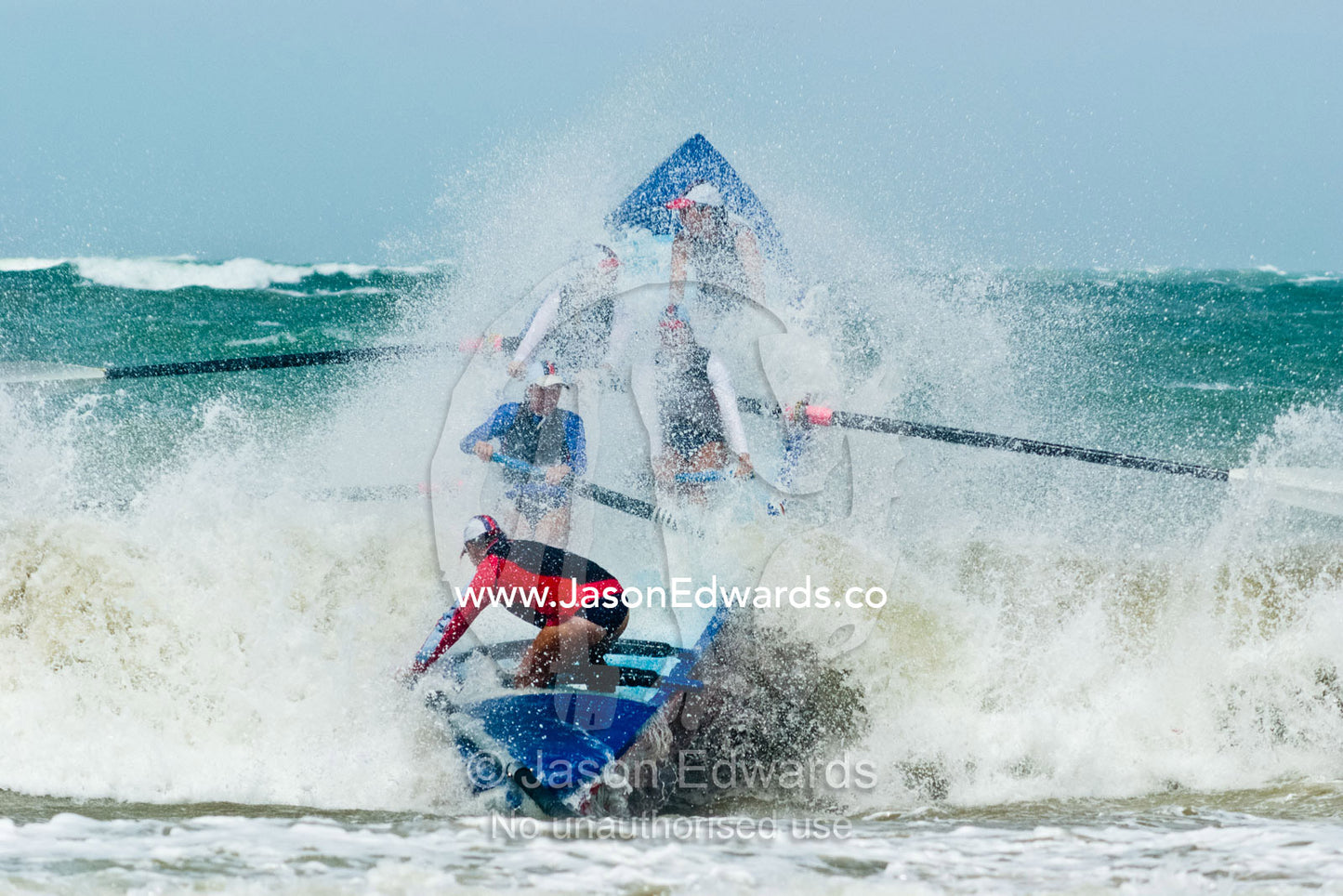 Women row a surf boat through raging seas at the Australian Titles. Australian Surfboat Open Titles, Fishermen's Bay, Torquay, Victoria, Australia.