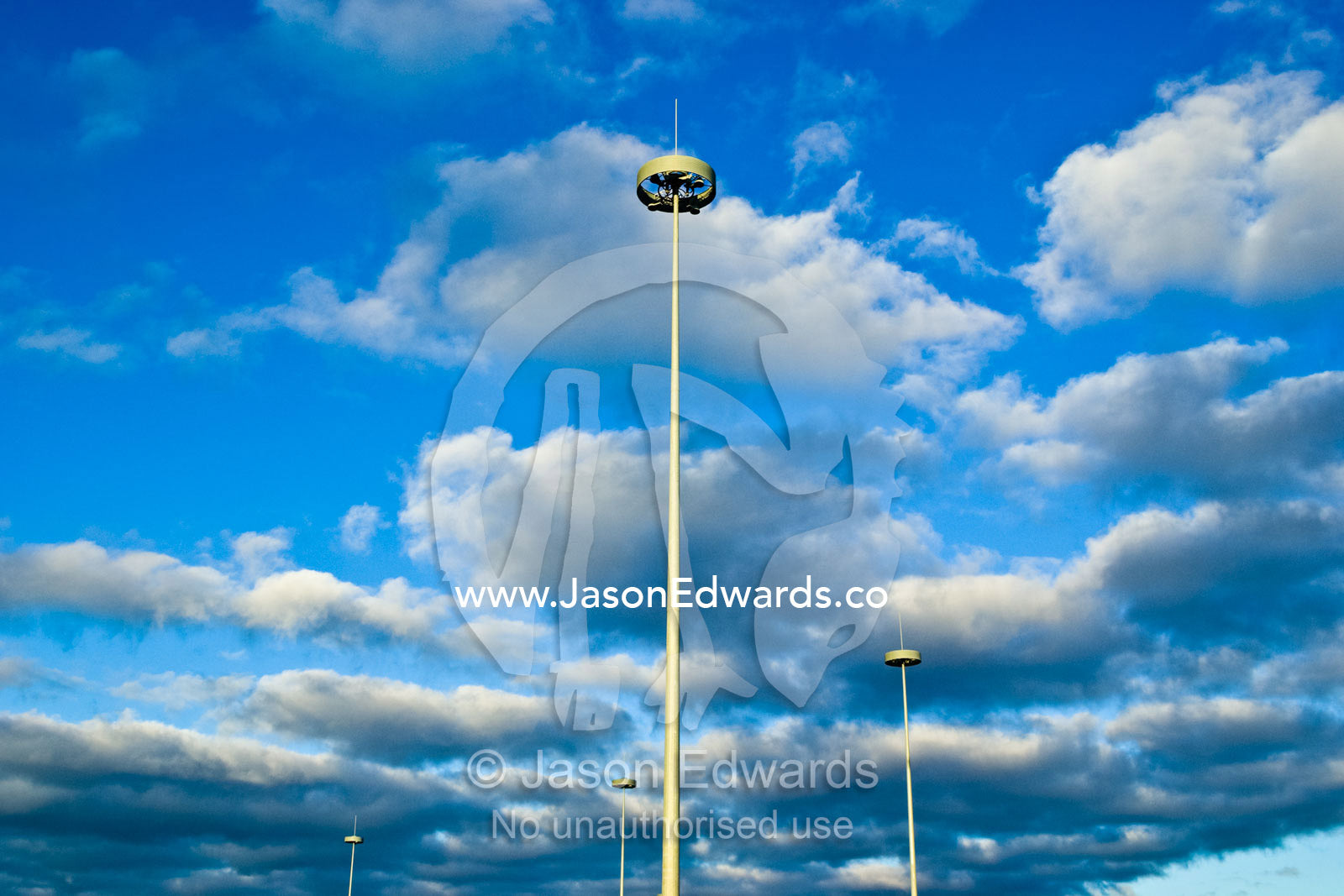 Modern needle-like highway lighting rising into a cloud-filled sky. West Gate Freeway and Princes Freeway Interchange, Laverton, Victoria, Australia