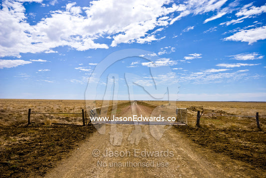 A rough dirt track and cattle grid forms a major road in the Outback. Hughenden Muttaburra Road, Queensland, Australia