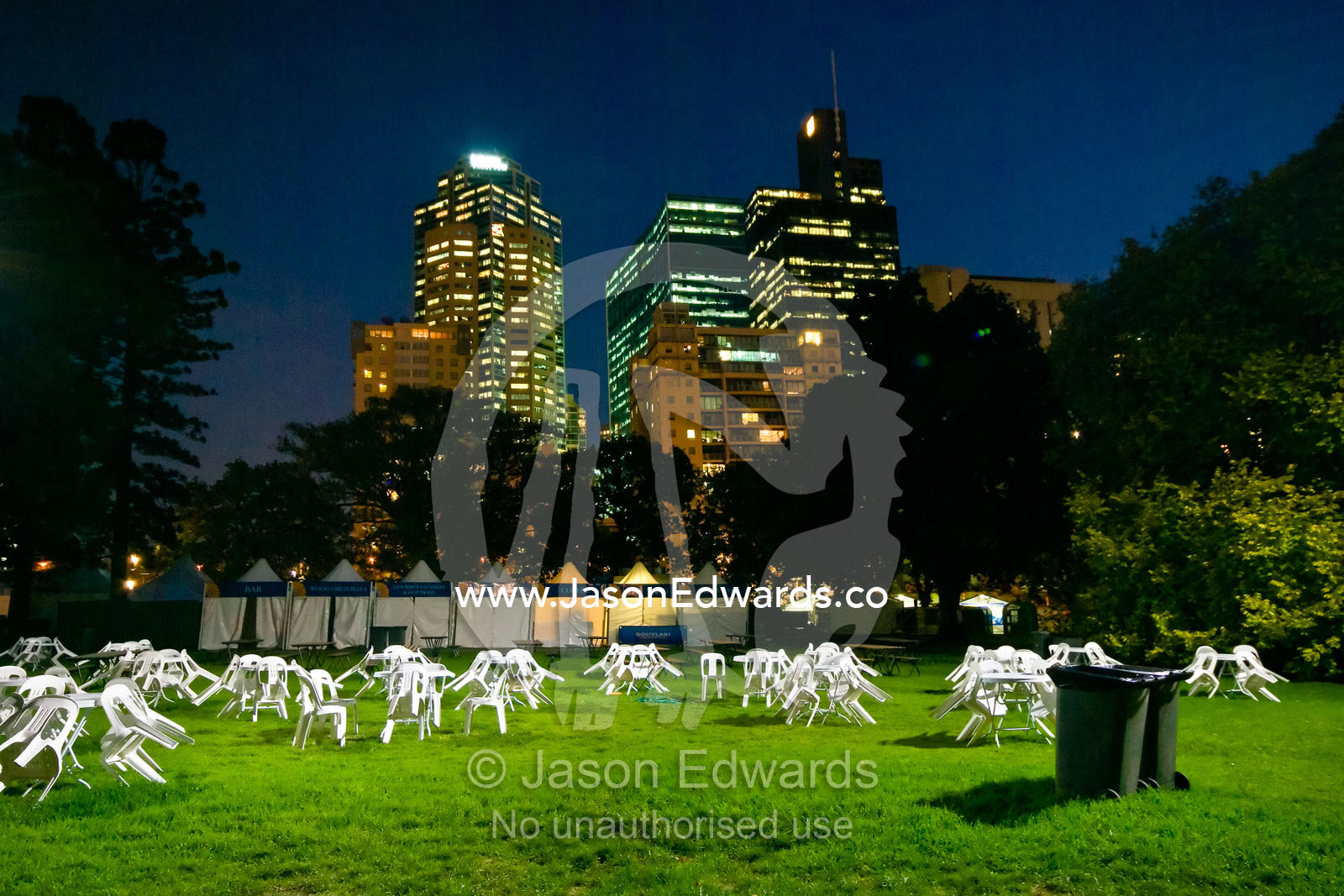 Plastic tables and chairs in empty parkland beneath a city skyline. Melbourne International Flower and Garden Show 2009, Carlton Gardens, Melbourne, Victoria, Australia