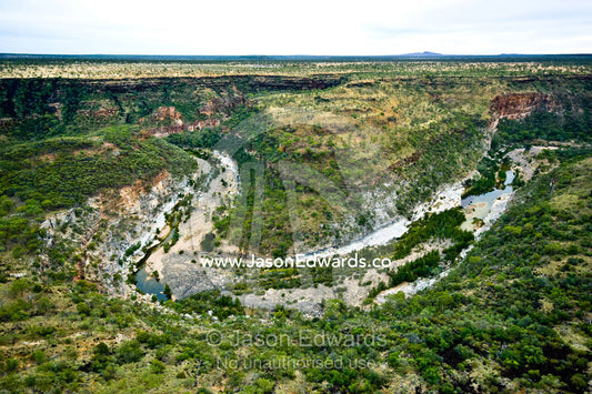 The sheer walls of a winding canyon cut through vast savannah plains. Porcupine Gorge National Park, Queensland, Australia.