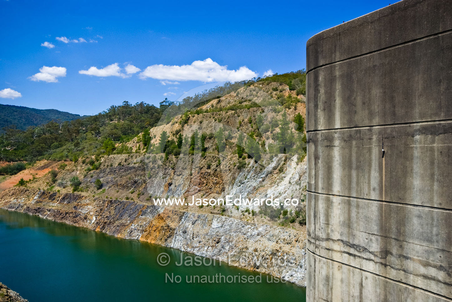 The concrete tower of a dam wall rises over dwindling water supplies. Eildon Weir Spillway, Lake Eildon, Victoria, Australia.