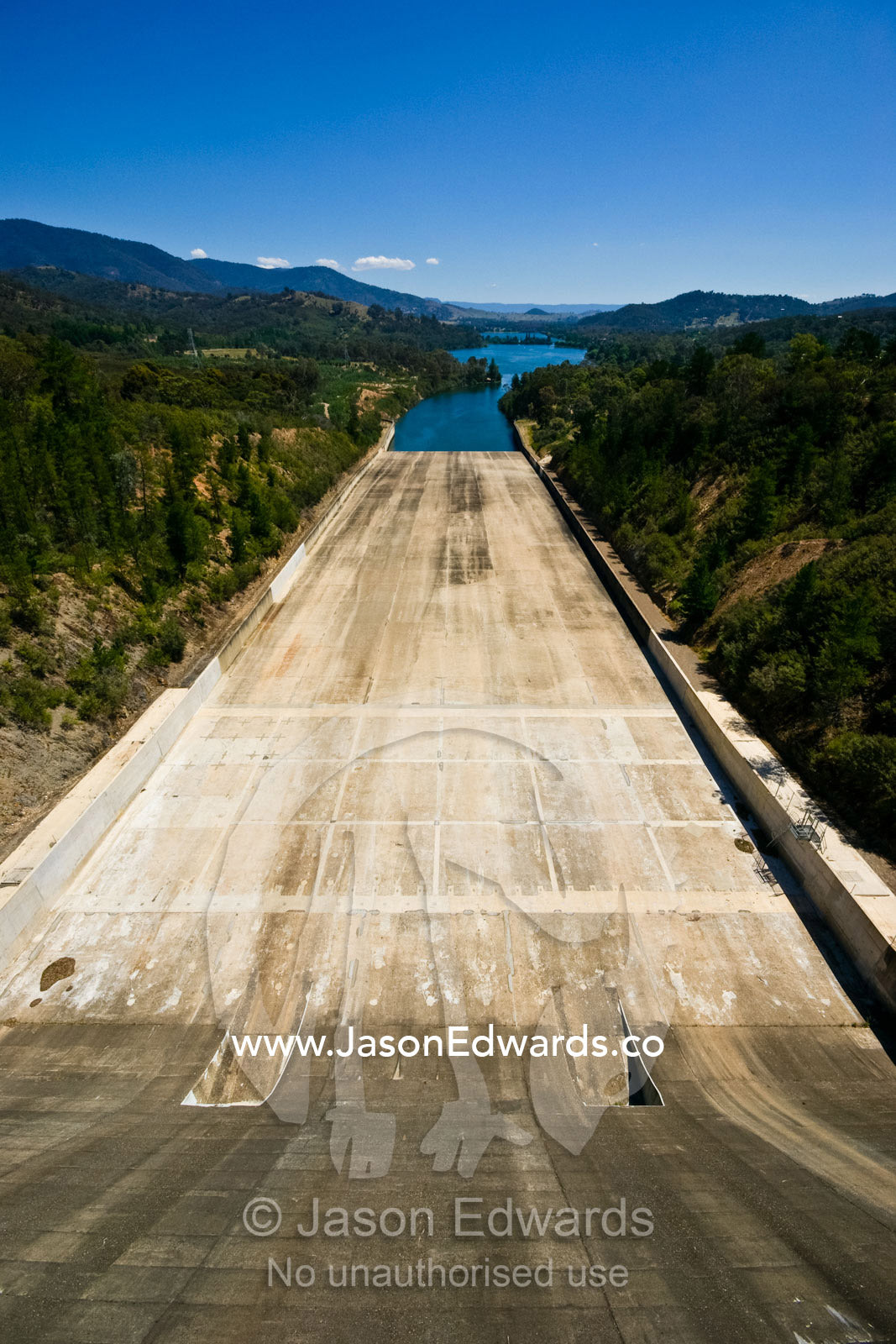 The massive concrete slide of a dam spillway and water reservoir. Eildon Weir Spillway, Lake Eildon, Victoria, Australia