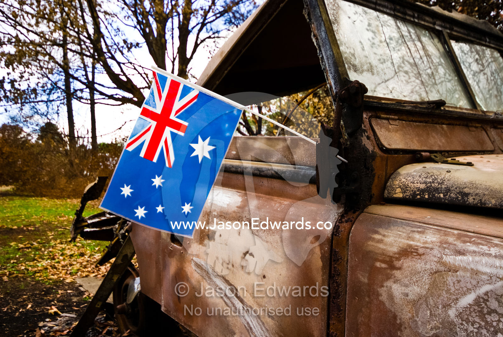 Fire survivors place an Australian flag on the wreck of a burnt 4wd. Kinglake West, Victoria, Australia