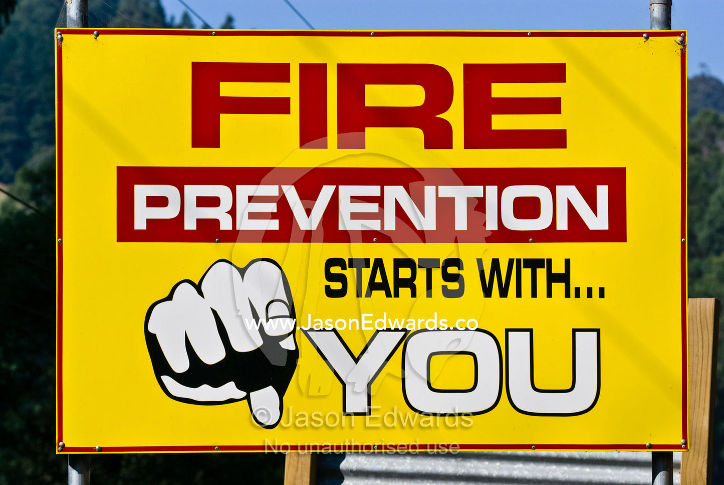 A bright yellow fire prevention sign by a country road gives warning. Healesville Kinglake Road, near Toolangi, Victoria, Australia