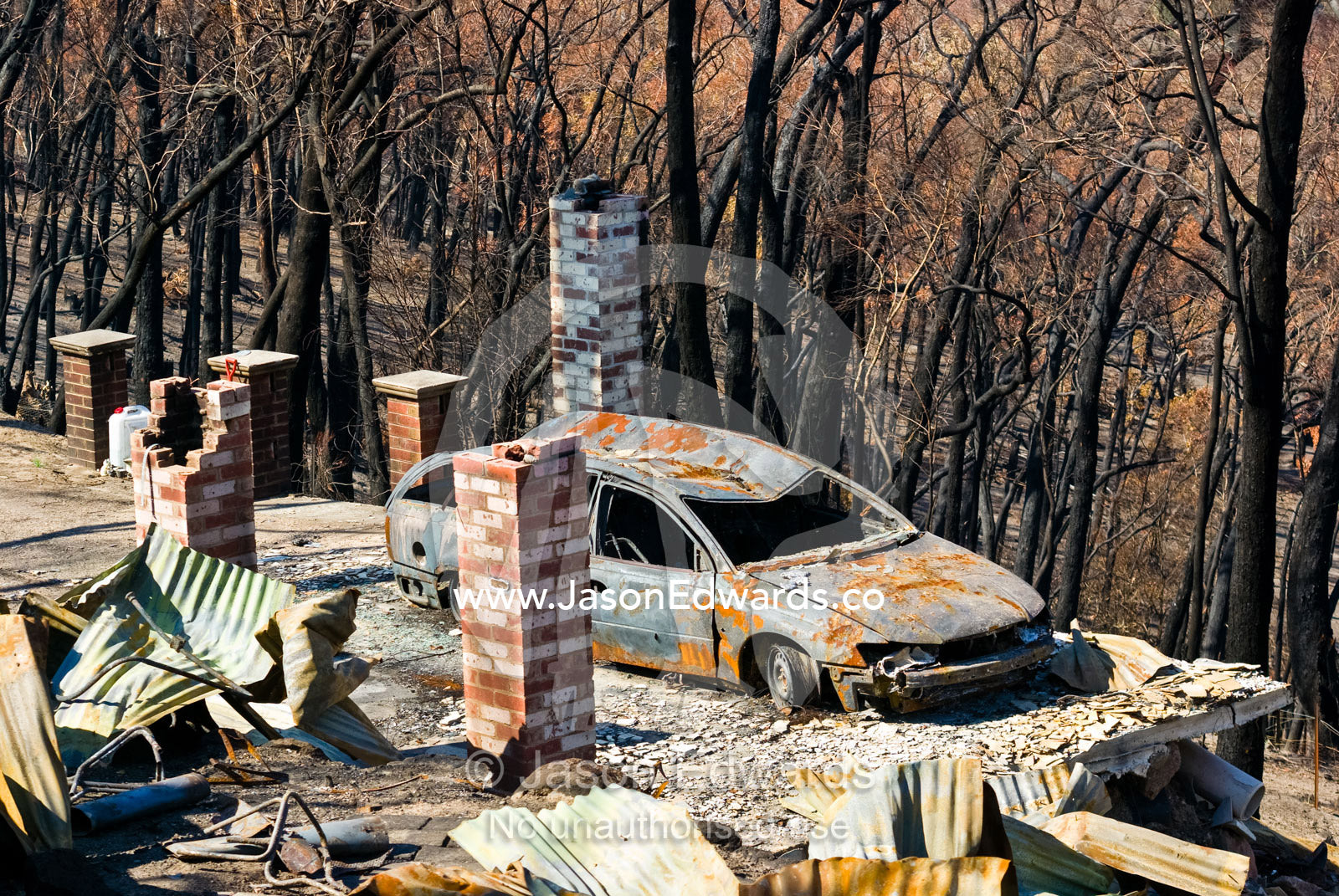 The passing of a bushfire leaves the charred remains of a home and car Near Humevale, Kinglake National Park, Victoria, Australia