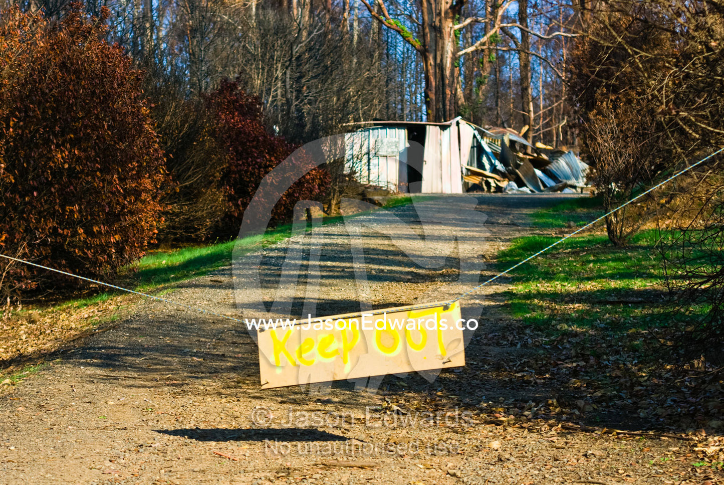 A sign posted outside a house destroyed by fire warns not to enter. Kinglake, Victoria, Australia