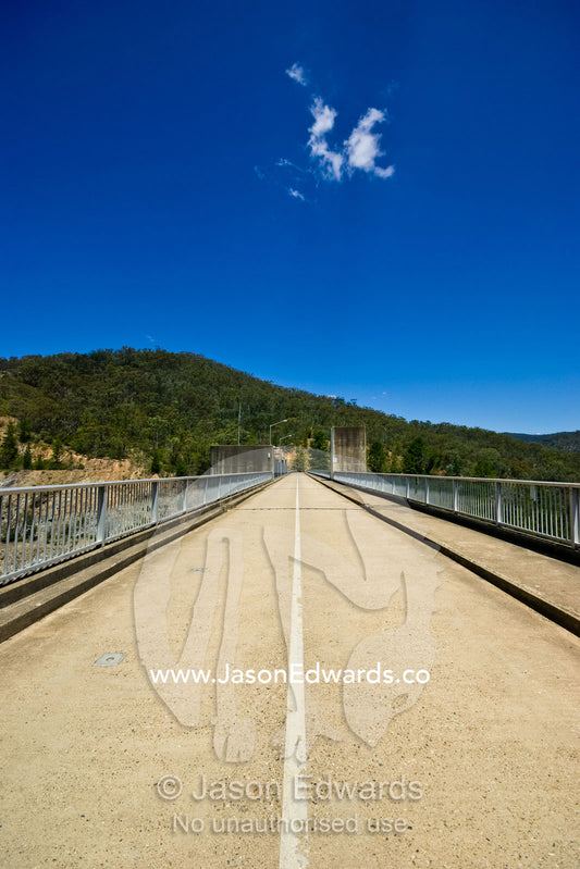 A long,straight bridge spans a gorge between forested mountains. Great Dividing Range, Eildon State Park, Victoria, Australia