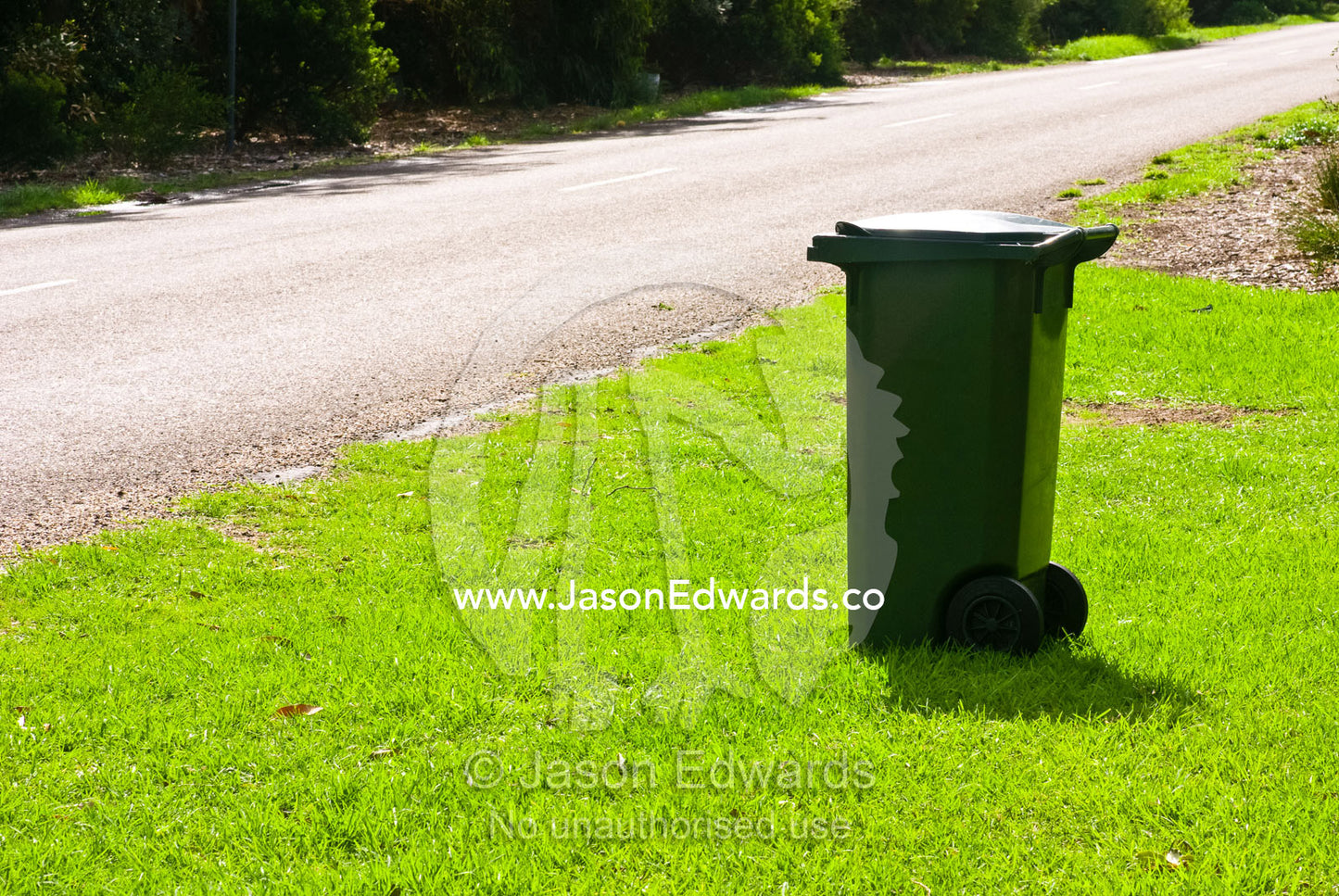 A council garbage bin waits by the road for collection in a rural town Sandy Point, Victoria, Australia