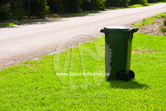 A council garbage bin waits by the road for collection in a rural town Sandy Point, Victoria, Australia