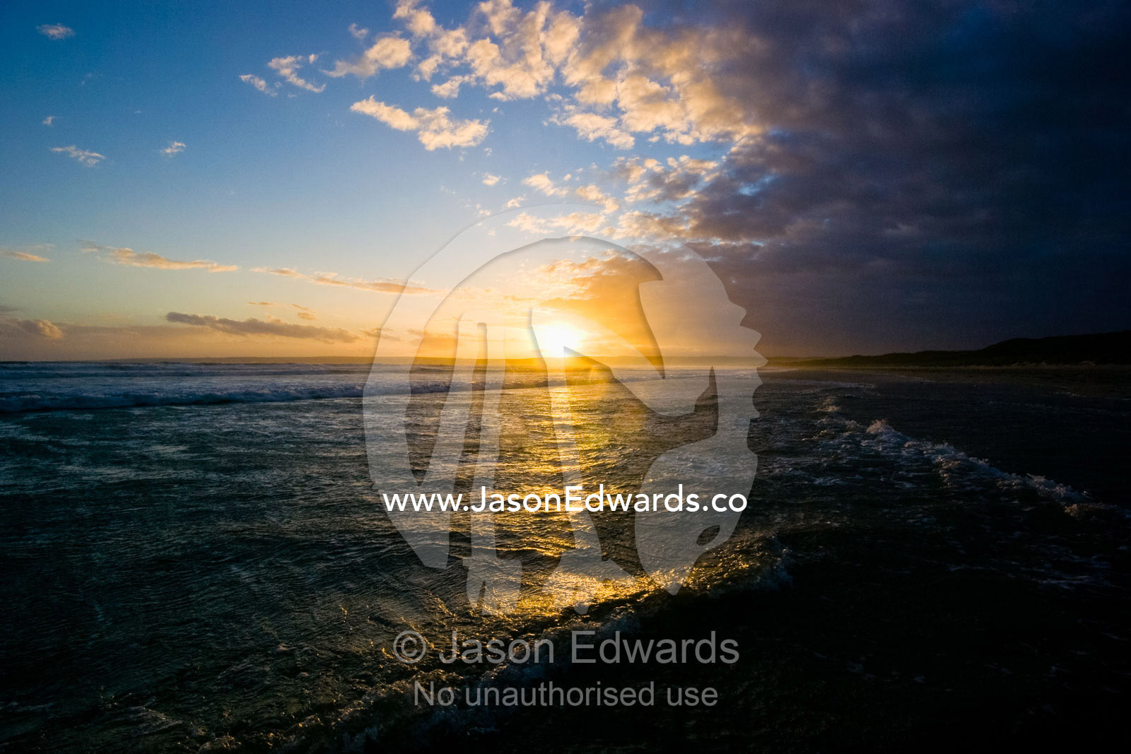 Storm clouds about to engulf the sunset as waves rolling into shore. Waratah Bay, Victoria, Australia.