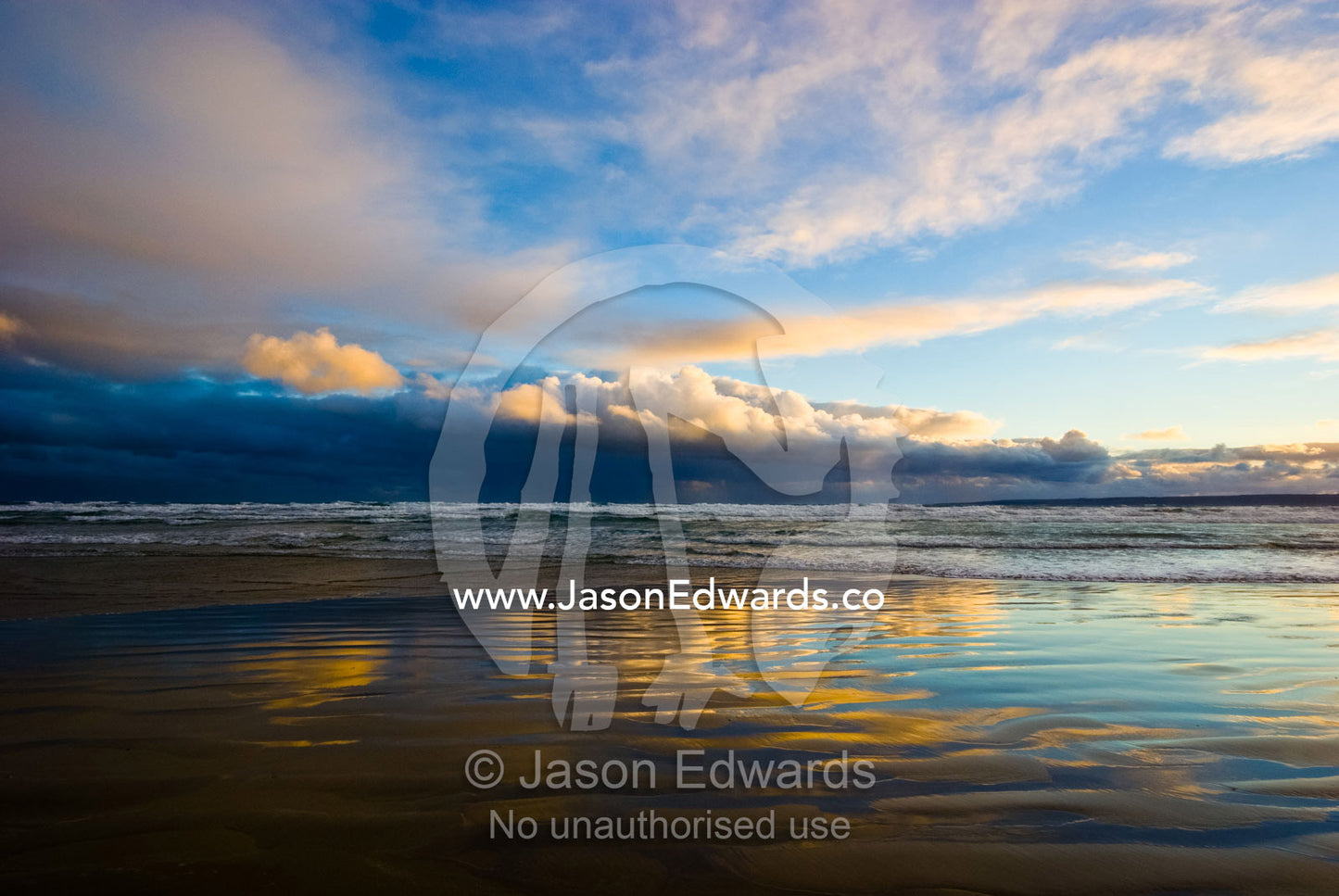 Thunderhead clouds reflect pastel hues in wet sand at twilight. Waratah Bay, Victoria, Australia.