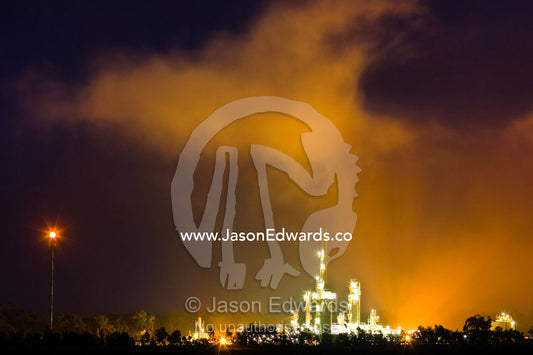 Pollution and steam rises from an illuminated gas refinery at night. Lang Lang Gas Plant, Lang Lang, Bass Valley, Victoria, Australia.