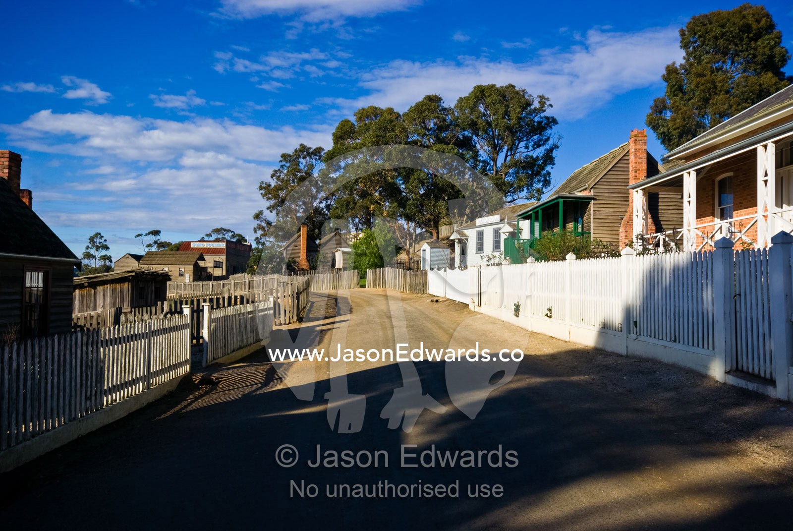 Colonial homes and picket fences line a dusty gold mining town street. Ballarat, Victoria, Australia.