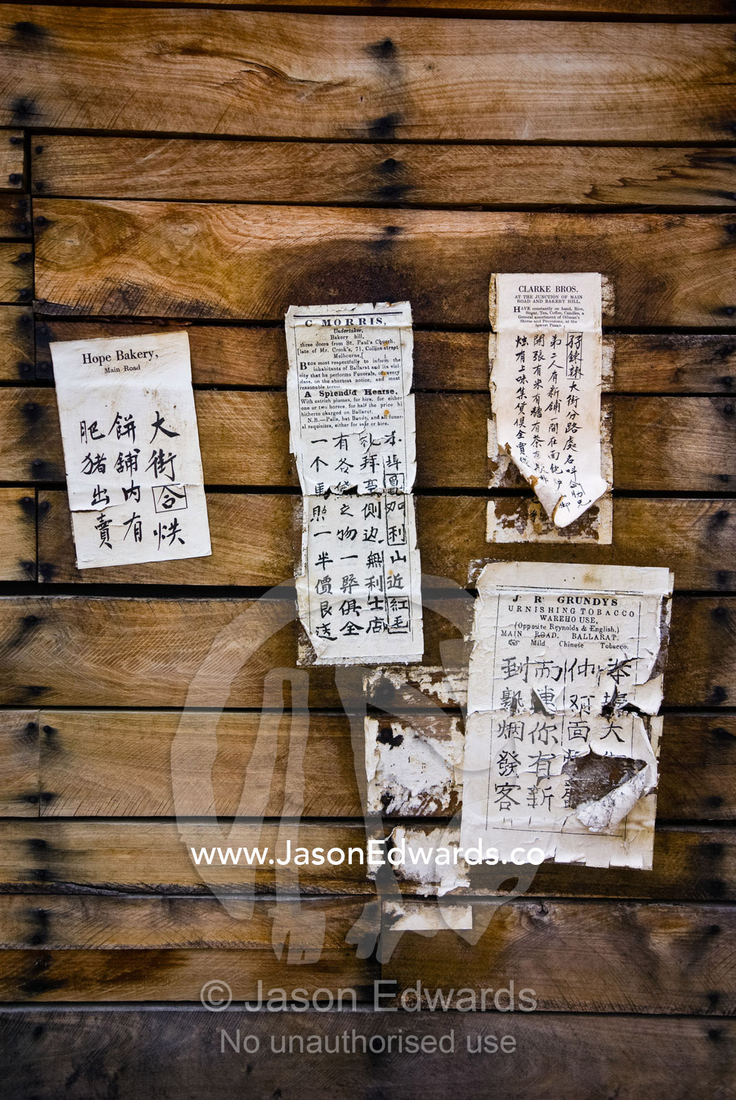 Chinese writing on printed public notices posted on a barn wall. Ballarat, Victoria, Australia.