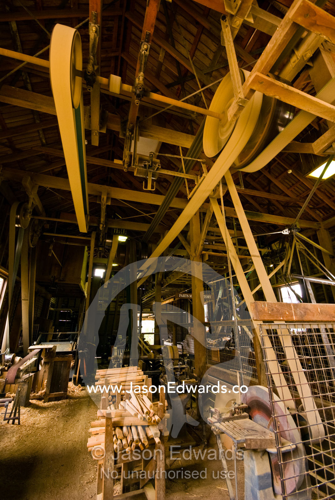 Large belts spin on pulleys on a wheelwright's plant sizing machine. Ballarat, Victoria, Australia