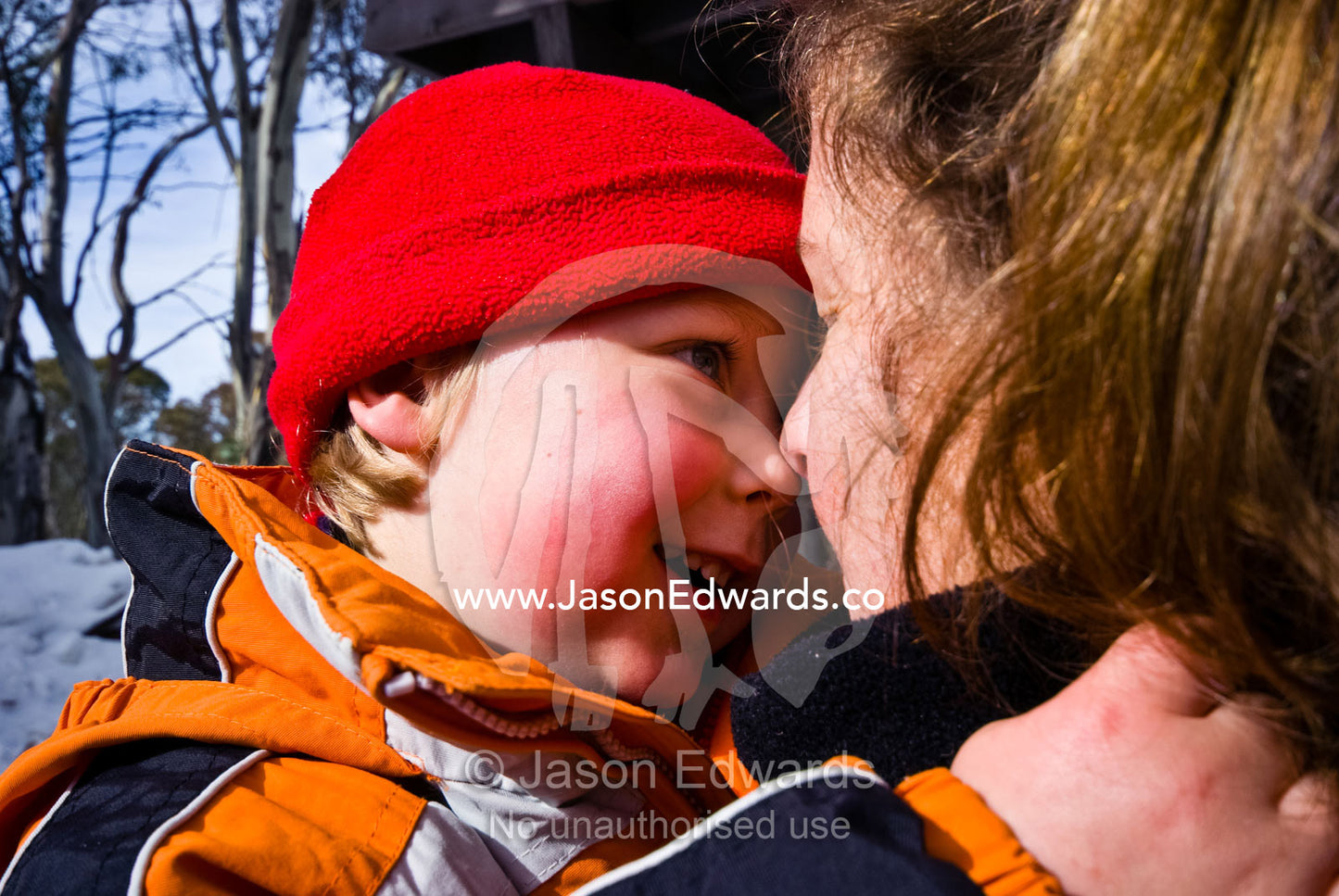 A mother and son touch cold noses on a snowy winter day. Dinner Plain, Great Dividing Range, Victoria, Australia.