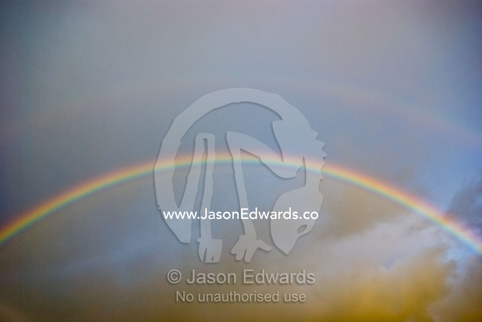 A rainbow arches over storm clouds on a winters afternoon. Sandy Point, Victoria, Australia