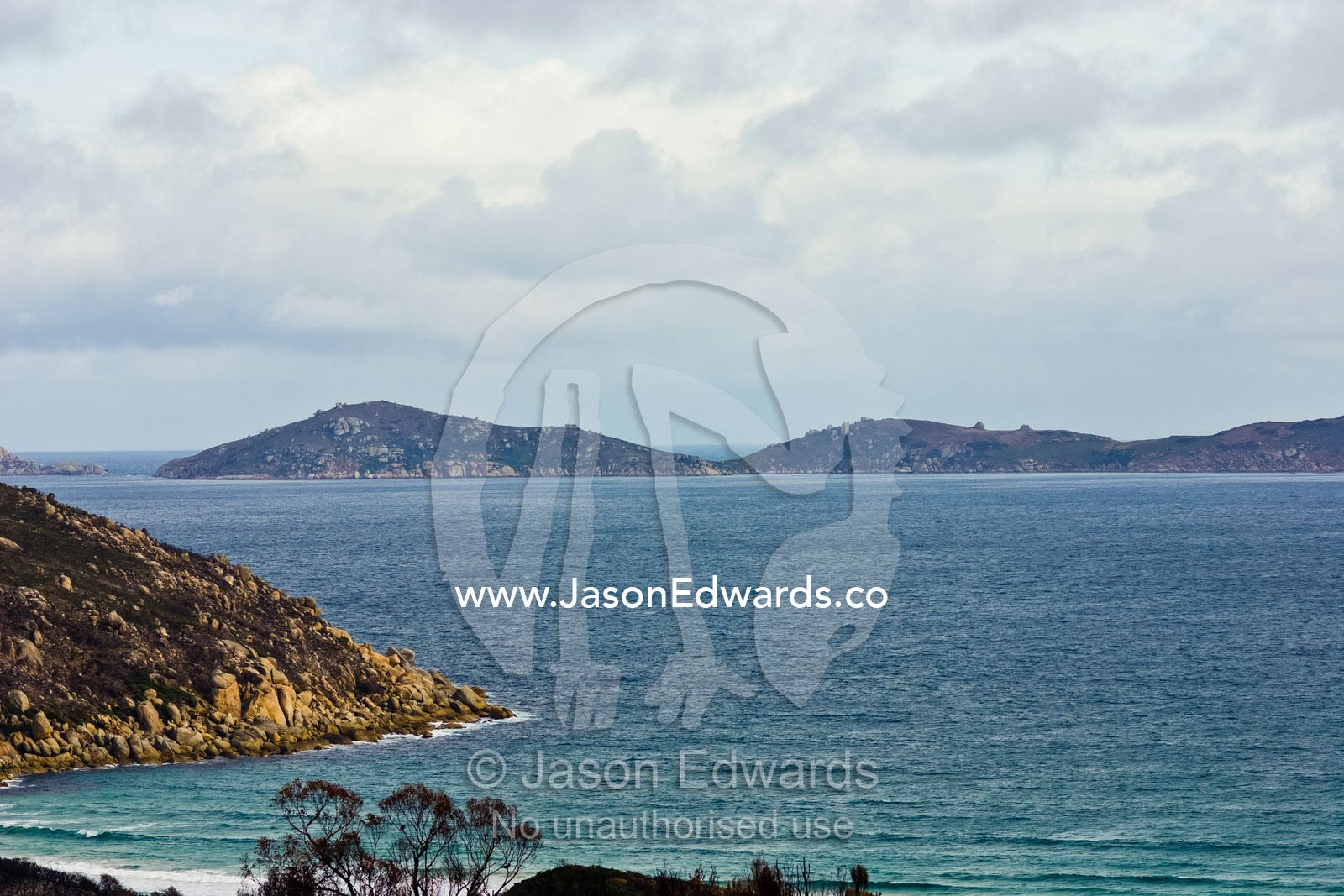 A sheltered granite bay and small offshore island with rolling hills. Picnic Bay, Norman Island, Wilsons Promontory National Park, Victoria, Australia