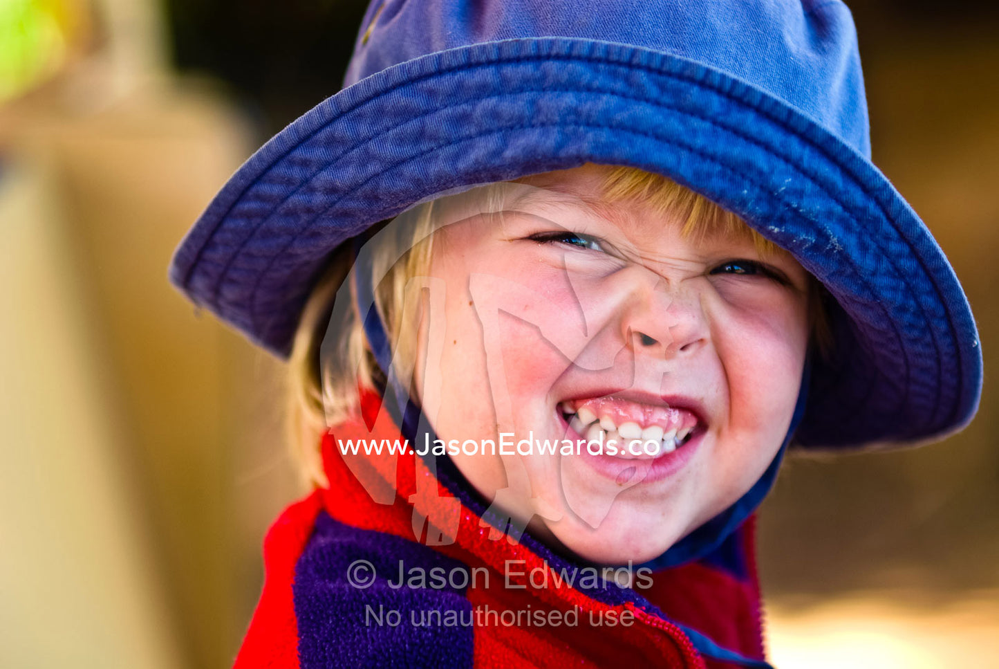 A small boy displaying his teeth and gums in a tiger growl. Werribee Open Range Zoo, Werribee, Victoria, Australia