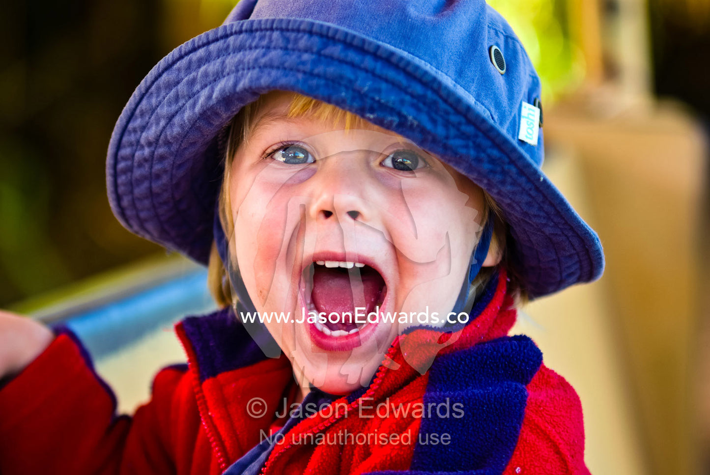 A small boy with bright eyes wearing a summer hat shouts for joy. Werribee Open Range Zoo, Werribee, Victoria, Australia