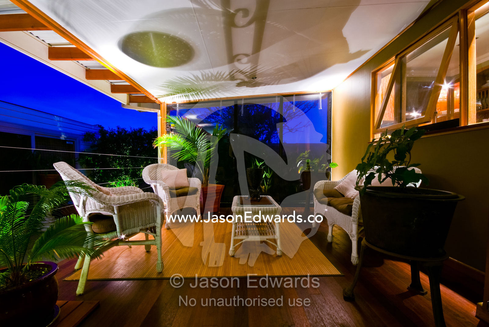 An outdoor patio and entertainment area overlooks a garden at night. Northcote, Victoria, Australia