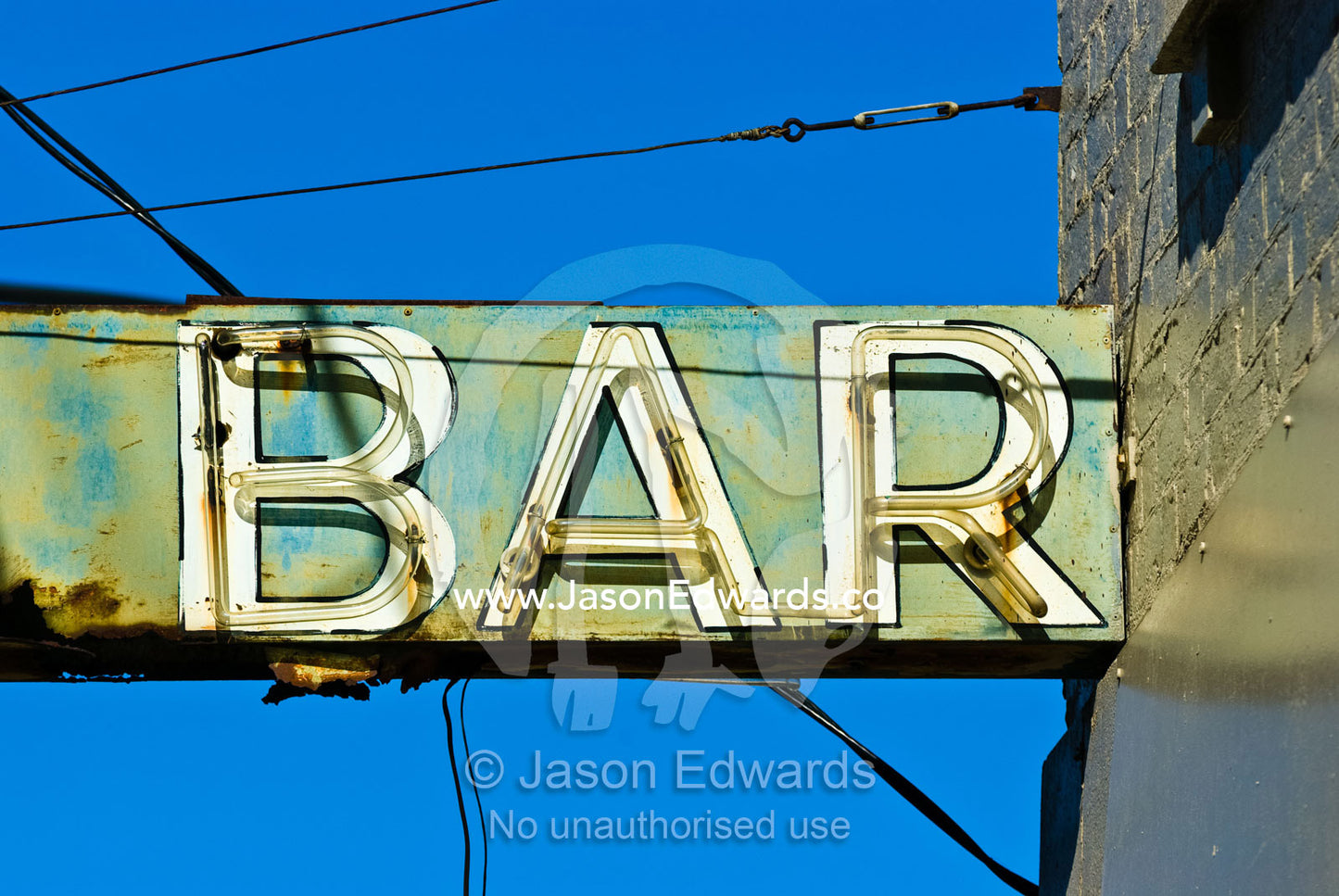 A rusting and dilapidated neon bar sign surrounded by cables and wires Collingwood, Victoria, Australia