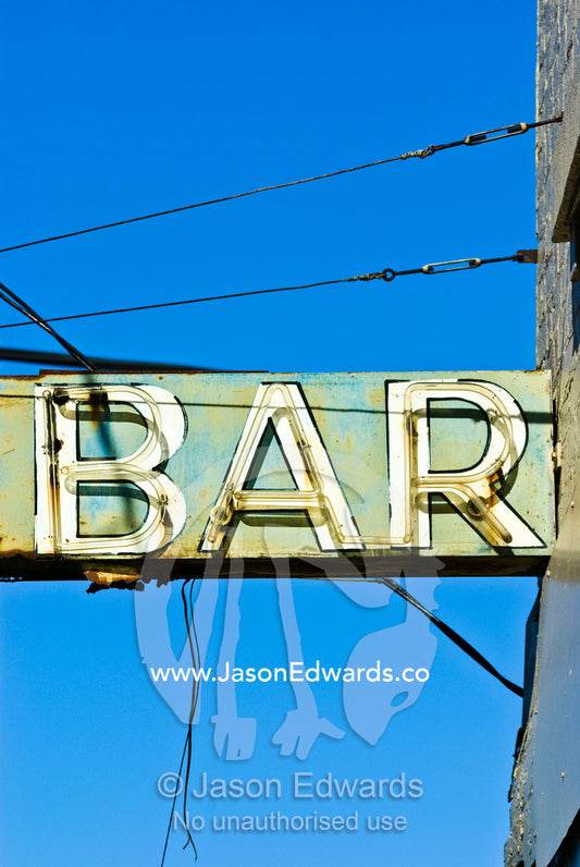 A rusting and delapidated neon bar sign surrounded by cables and wires Collingwood, Victoria, Australia