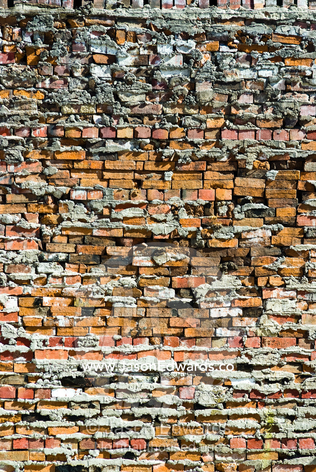 Poor workmanship shows in a brick wall covered in excess cement. Collingwood, Victoria, Australia