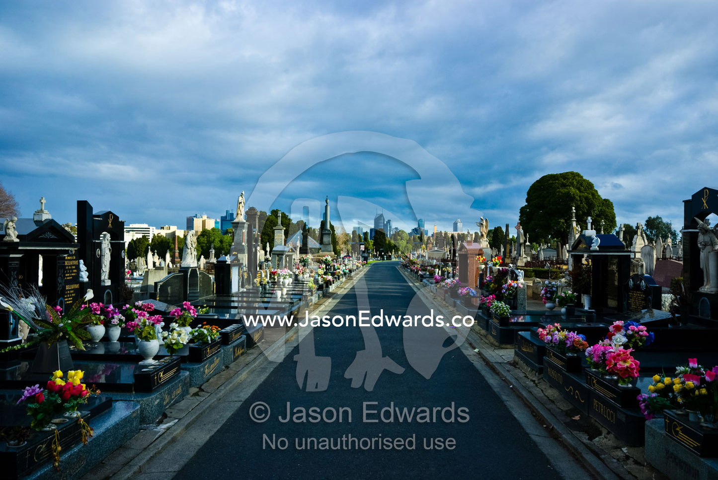 A footpath through rows of tombstones and graves in an old graveyard. Melbourne General Cemetery, Parkville, Victoria, Australia