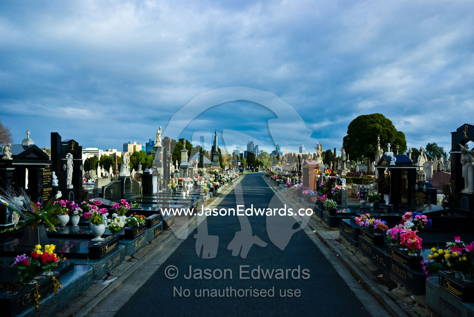 A footpath through rows of tombstones and graves in an old graveyard. Melbourne General Cemetery, Parkville, Victoria, Australia