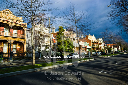 Winter trees line an inner city street and old English terrace homes. Princes Hill, North Carlton, Victoria, Australia