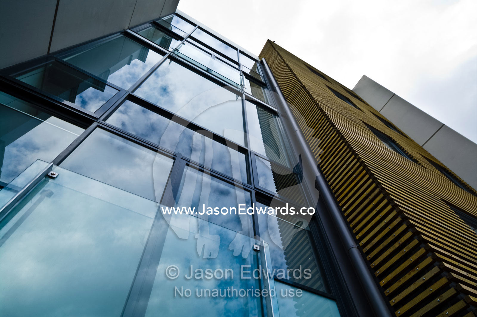 Clouds reflected in the glass facade of a city apartment complex. North Melbourne, Victoria, Australia