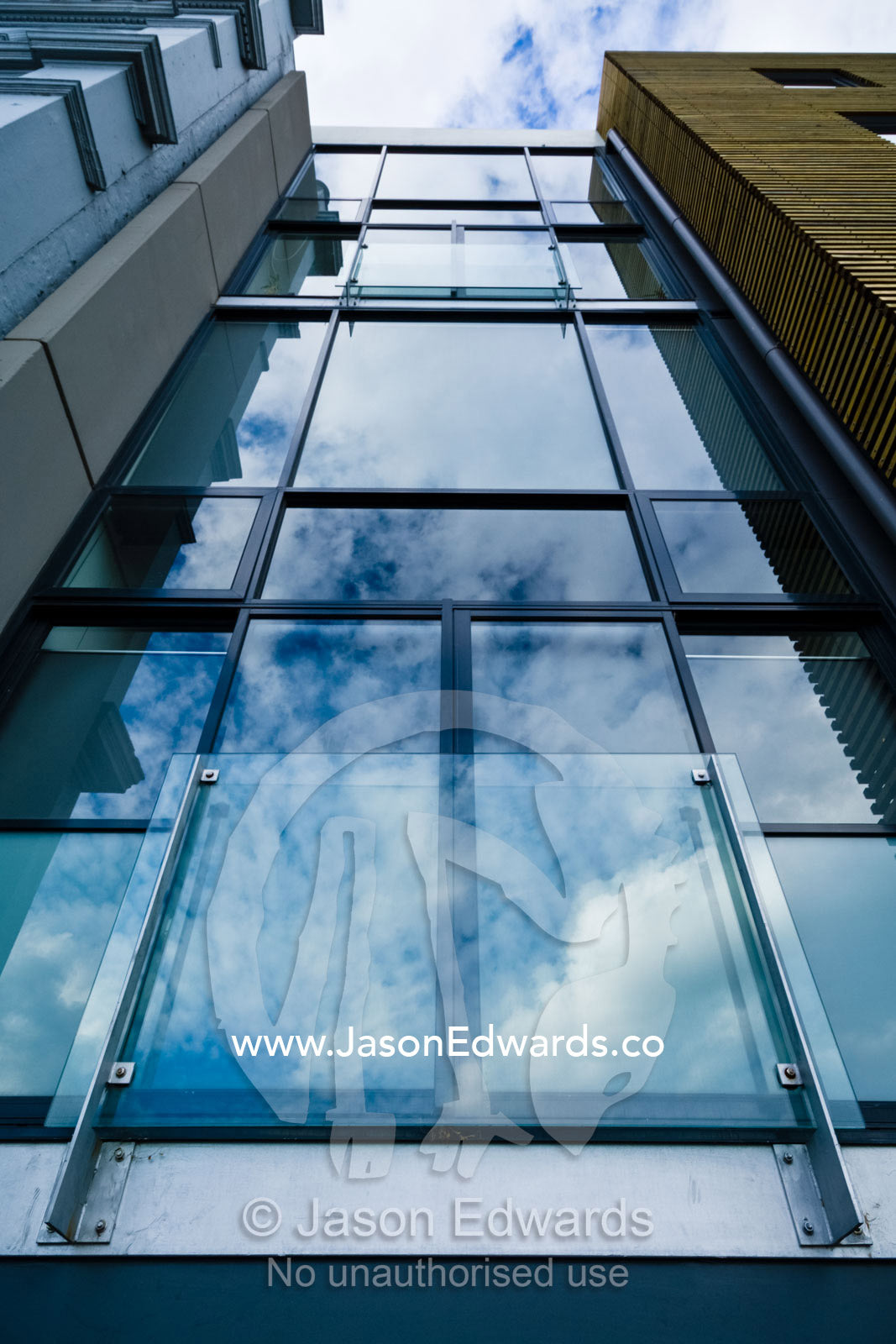 Clouds reflected in the glass facade of a city apartment complex. North Melbourne, Victoria, Australia
