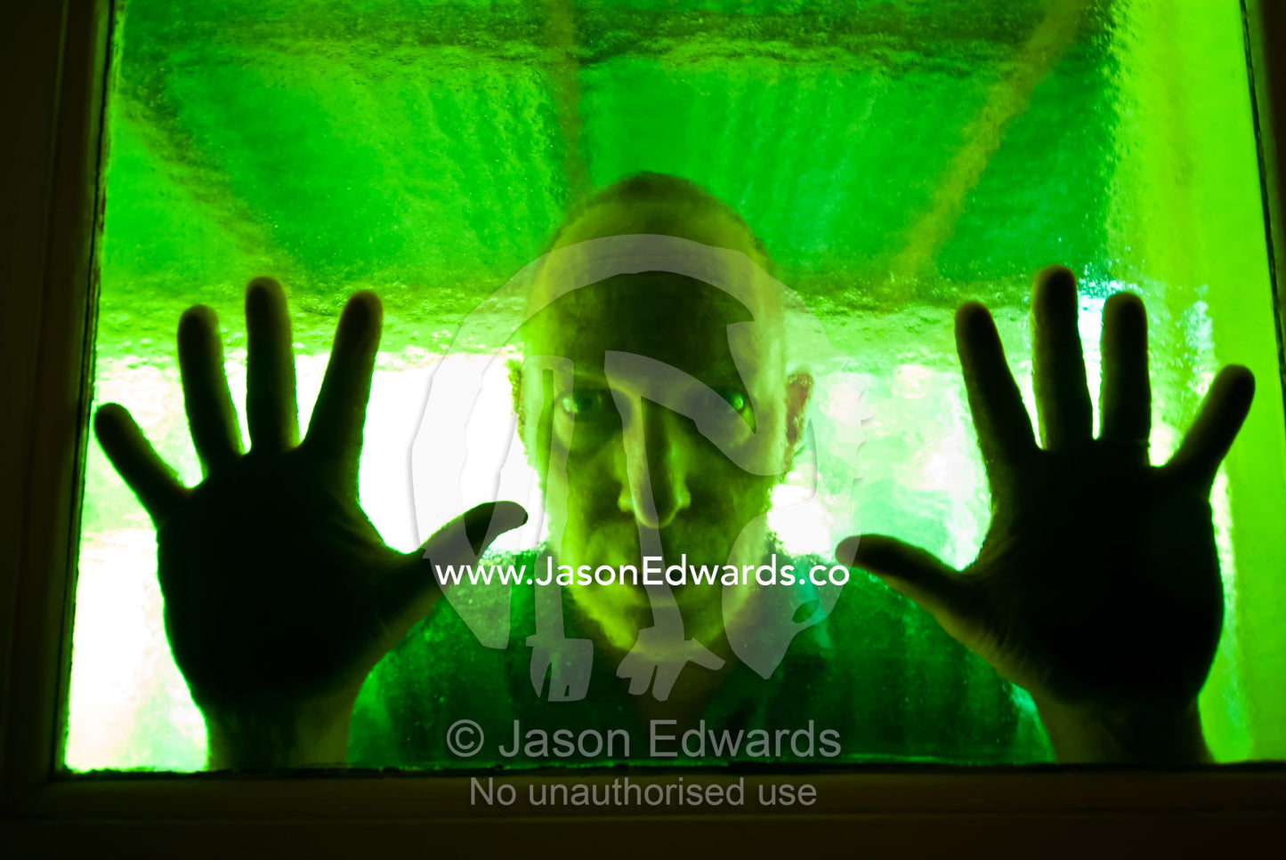 An evil-looking man peers into a house through antique green glass. Castlemaine, Victoria, Australia