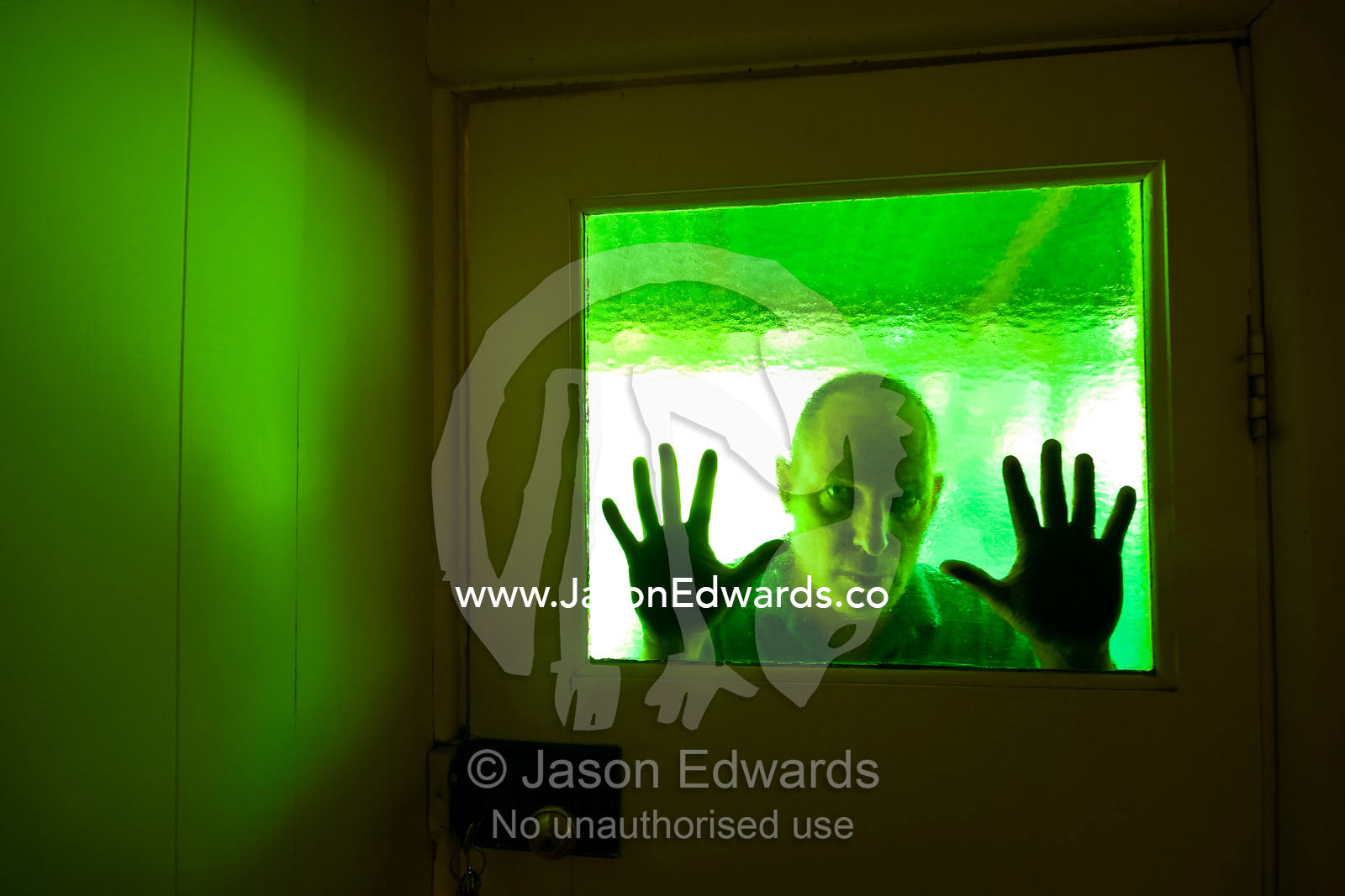 An evil-looking man peers into a house through antique green glass. Castlemaine, Victoria, Australia