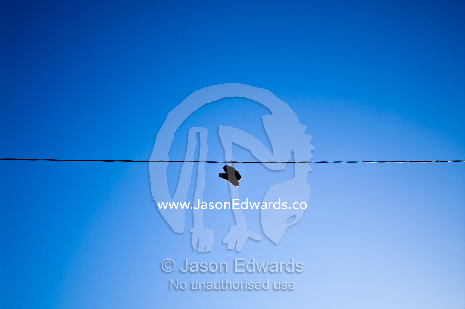 A pair of shoes hang from an electricity cable thrown there as a prank Carlton North, Victoria, Australia